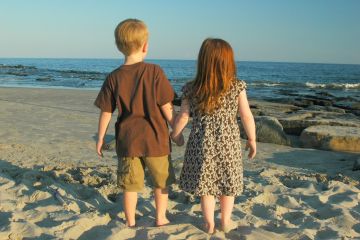 Bilde av gutt og jente på strand som leier