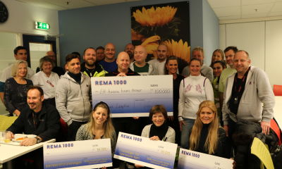 Glade mottakere av sjekker sammen med ansatte fra REMA 1000.