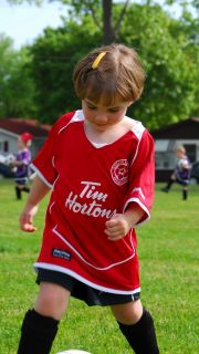 Bilde av liten jente som sparker fotball