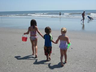 Bilde av tre små barn på en strand